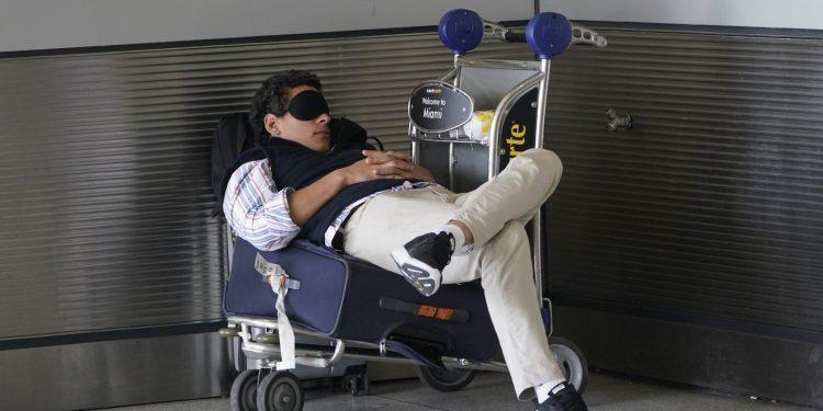 Ταξιδιώτης παίρνει έναν υπνάκο καθώς περιμένει έξω από το Διεθνές Αεροδρόμιο του Μαϊάμι, την Παρασκευή 1 Ιουλίου 2022. (AP Photo/Wilfredo Lee, Αρχείο)