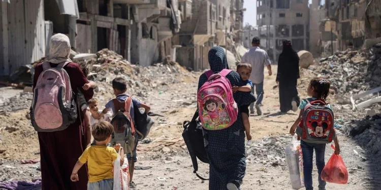 Μητέρες με παιδιά στο δρόμο προς αναζήτηση καταφυγίου, τροφής και νερού. AP Photo/Enas Rami