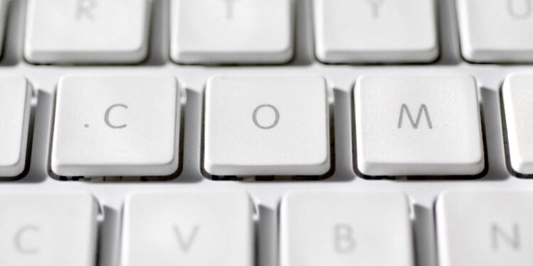 Στον κόσμο των domain names, λίγα γράμματα μπορούν να μετατραπούν σε ψηφιακούς χώρους αξίας δεκάδων εκατομμυρίων ευρώ. Κανένα τετραγωνικό. Καμία θερμοκρασία ή καιρική μεταβολή. Άυλη γη. Ο χώρος μπορεί να έχει διεύθυνση και μπορεί να κοστίζει δεκάδες εκατομμύρια. Στην αγορά των domain names, μια λέξη με την κατάληξη .com μπορεί να λειτουργήσει σαν προνομιακό οικόπεδο στο ψηφιακό σύμπαν. Τα «οικόπεδα» του Internet: Γιατί ένα domain name μπορεί να αξίζει εκατομμύρια Όποιος κατέχει το όνομα που θέλουν οι υπόλοιποι βρίσκεται πάνω σε ένα ψηφιακό κομμάτι γης που δεν μπορεί να αναπαραχθεί από άλλον, όσο ισχυρός κι αν είναι. Photo: 123RF Στις 30 Μαΐου 2019 άλλαξε χέρια μια λέξη. Η αμερικανική MicroStrategy, εταιρεία κατασκευής λογισμικού που βοηθά επιχειρήσεις να αναλύουν τα δεδομένα τους, πούλησε το όνομα Voice.com στην Block.one, μια εταιρεία τεχνολογίας, έναντι περίπου 26,8 εκατομμυρίων ευρώ. Η Block.one είχε πια δικαίωμα να χρησιμοποιεί το domain. Τι ήταν το Voice.com; Ένα κοινωνικό δίκτυο που φιλοδοξούσε να αποτελέσει εναλλακτική σε πλατφόρμες όπως το Facebook. Η υπηρεσία έκλεισε το 2023, αφού προηγουμένως είχε στραφεί περισσότερο προς τους δημιουργούς ψηφιακού περιεχομένου και τα ψηφιακά πιστοποιητικά ιδιοκτησίας που μπορούν να συνδέονται, για παράδειγμα, με ψηφιακά έργα ή άλλα συλλεκτικά αντικείμενα. Τα 26,8 εκατομμύρια ευρώ, το κόστος της αγοράς του παραπάνω ονόματος, δεν περιελάμβαναν καμία υλική υποδομή. Η επένδυση αφορούσε μια λέξη πριν από το .com. Η συναλλαγή απέφερε στη MicroStrategy κέρδη εκατομμυρίων ευρώ. Πώς μπορεί μια διαδικτυακή διεύθυνση να αξίζει όσο ένα προνομιακό ακίνητο; Η απάντηση ξεκινά από τη διαχρονική οικονομική αρχή: τη μοναδικότητα. Στο διαδίκτυο μπορεί να υπάρχει μόνο ένα Voice.com, μόνο ένα Cars.com, μόνο ένα Hotels.com. Ένας παράλληλος κόσμος ζει στον πυρετό της πρώτης κατοχύρωσης του ιδανικού, ευκολομνημόνευτου ονόματος. Όποιος κατέχει το όνομα που θέλουν οι υπόλοιποι βρίσκεται πάνω σε ένα ψηφιακό κομμάτι γης που δεν μπορεί να αναπαραχθεί από άλλον, όσο ισχυρός κι αν είναι. Το μεγάλο ψάρι δεν τρώει πάντα το μικρό. Αν το δεύτερο έχει κατοχυρώσει το όνομα που επιθυμεί το πρώτο, η αγορά του μπορεί να κοστίσει ακριβά. Η διεύθυνση ως περιουσιακό στοιχείο Το domain name είναι η διαδικτυακή διεύθυνση που πληκτρολογούμε για να φτάσουμε σε έναν ιστότοπο. Οι υπολογιστές, όμως, βρίσκουν τις ιστοσελίδες μέσω αριθμητικών διευθύνσεων. Το Domain Name System, το DNS, λειτουργεί σαν τηλεφωνικός κατάλογος του Internet: συνδέει το όνομα που θυμάται ο άνθρωπος με τη σωστή αριθμητική διεύθυνση. Ο χρήστης δεν χρειάζεται να θυμάται αριθμούς. Θυμάται λέξεις. Θα μπορούσε ένας Αθηναίος να μη θυμάται ποια είναι η οδός Σταδίου; Ή θα μπορούσαμε ποτέ να φανταστούμε άλλο κεντρικό δρόμο στην πόλη που θα λεγόταν Σταδίου 2; Κάπως έτσι λειτουργεί και ο ψηφιακός κόσμος. Το μεγάλο άυλο παζάρι αρχίζει όταν κάποιος έχει κατοχυρώσει το όνομα που θα ήθελε να έχει κάποιος άλλος. Τα «οικόπεδα» του Internet: Γιατί ένα domain name μπορεί να αξίζει εκατομμύρια Επενδυτές αγοράζουν domains που θεωρούν ότι θα αποκτήσουν μεγαλύτερη αξία και brokers μεσολαβούν στις συμφωνίες. @ Sasun Bughdaryan / Unsplash Ένα σύντομο domain, εύκολο να προφερθεί και να γραφτεί, που περιγράφει μια μεγάλη εμπορική κατηγορία ή μπορεί να γίνει ισχυρό brand, έχει από μόνο του εμπορική δύναμη. Το Insurance.com δεν χρειάζεται ιδιαίτερη εισαγωγή για την εμπορική του χρήση. Το ίδιο και το Hotels.com. Η διαδικτυακή διεύθυνση λειτουργεί ως πινακίδα που αναγνωρίζεται αμέσως. Αν το Internet είναι, εκτός των άλλων, και μια παράλληλη αγορά που διαρκώς μεγαλώνει, η αναγνωρισιμότητα είναι σαν οικόπεδο με θέα στη θάλασσα: όλοι θα ήθελαν θέση μπροστά στο κύμα. 401,6 εκατομμύρια domain names Στο τέλος του δεύτερου τριμήνου του 2026 υπήρχαν 401,6 εκατομμύρια καταχωρισμένα domain names παγκοσμίως, αυξημένα κατά 8,1% μέσα σε έναν χρόνο. Μόνο τα .com έφταναν τα 166,6 εκατομμύρια. Η συντριπτική πλειονότητα των μοναδικών ονομάτων δεν αξίζει εκατομμύρια. Πολλά domains δεν αξίζουν περισσότερο από το ετήσιο κόστος ανανέωσής τους. Όμως στα μεγάλα ποσά οι κανόνες αλλάζουν. Γύρω από αυτά τα ονόματα έχει δημιουργηθεί αγορά μεταπώλησης. Επενδυτές αγοράζουν domains που θεωρούν ότι θα αποκτήσουν μεγαλύτερη αξία και brokers μεσολαβούν στις συμφωνίες. Για παράδειγμα, το 2025 το Phoenix.com πωλήθηκε έναντι περίπου 982.000 ευρώ. Στη συναλλαγή μεσολάβησε η Grit Brokerage, εταιρεία που ειδικεύεται στη μεσιτεία και στις αγοραπωλησίες domain names, ενώ το χρηματικό σκέλος πέρασε και από την Escrow.com, μια πλατφόρμα ασφαλών συναλλαγών που κρατά τα χρήματα έως ότου ολοκληρωθεί η μεταβίβαση. Οι εταιρείες ή οι ιδιώτες που βρίσκονταν στις δύο πλευρές της συγκεκριμένης αγοραπωλησίας δεν δημοσιοποιήθηκαν. Τα «οικόπεδα» του Internet: Γιατί ένα domain name μπορεί να αξίζει εκατομμύρια Η Crypto.com, μια διεθνής πλατφόρμα μέσω της οποίας περισσότεροι από 150 εκατομμύρια χρήστες μπορούν να αγοράζουν και να πωλούν κρυπτονομίσματα. AI και γεωγραφία – Το παράδειγμα της Ανγκουίλα Κάθε τεχνολογική έκρηξη παράγει τη δική της γεωγραφία. Και αυτή τη φορά μια μικρή χώρα της Καραϊβικής βρέθηκε, σχεδόν από τύχη, να κατέχει δύο από τα πιο περιζήτητα γράμματα του Internet. Η άνοδος της τεχνητής νοημοσύνης εκτόξευσε το ενδιαφέρον για domains με κατάληξη .ai, η οποία αποτελεί παράλληλα τον εθνικό διαδικτυακό κωδικό της Ανγκουίλα. Από την έκρηξη της γενετικής τεχνητής νοημοσύνης, ιδιαίτερα μετά την εμφάνιση του ChatGPT τον Νοέμβριο του 2022, τα δύο γράμματα άρχισαν να λειτουργούν διεθνώς σαν συνώνυμο του artificial intelligence. Η σύμπτωση αποδείχθηκε χρυσοφόρα. Οι καταχωρίσεις με κατάληξη .ai αυξήθηκαν από 144.000 το 2022 σε 354.000 το 2023. Η Ανγκουίλα εισπράττει χρήματα κάθε φορά που κατοχυρώνεται ή ανανεώνεται ένα όνομα με κατάληξη .ai. Το μοντέλο χρέωσης προέβλεπε 140 δολάρια για δύο χρόνια κατοχύρωσης, ενώ περίπου εννέα στα δέκα domains ανανεώνονται. Η έκρηξη των καταχωρίσεων απέφερε έτσι το 2023 στην κυβέρνηση 87 εκατομμύρια δολάρια Ανατολικής Καραϊβικής, περίπου 28,6 εκατομμύρια ευρώ, ποσό που αντιστοιχούσε σε περισσότερο από το 20% των συνολικών κρατικών εσόδων. Το 2025 το AI.com άλλαξε χέρια έναντι περίπου 62,6 εκατομμυρίων ευρώ. Ήταν η μεγαλύτερη δημοσιοποιημένη πώληση domain name μέχρι σήμερα. Αγοραστής ήταν ο Kris Marszalek, συνιδρυτής και CEO της Crypto.com. Ο πωλητής δεν δημοσιοποιήθηκε. Η Crypto.com είναι διεθνής πλατφόρμα μέσω της οποίας περισσότεροι από 150 εκατομμύρια χρήστες μπορούν να αγοράζουν και να πωλούν κρυπτονομίσματα όπως Bitcoin και Ethereum. Κάτω από το AI.com ο Marszalek δημιούργησε πλατφόρμα με προσωπικούς AI agents: προγράμματα τεχνητής νοημοσύνης που, με άδεια του χρήστη, μπορούν να εκτελούν εργασίες για λογαριασμό του, όπως να οργανώνουν δουλειές, να στέλνουν μηνύματα ή να χρησιμοποιούν εφαρμογές. Η εποχή δημιουργεί τις δικές της υπεραξίες. Δύο γράμματα μπορούν να αξίζουν όσο ένας ουρανοξύστης σε μητρόπολη. Τα «οικόπεδα» του Internet: Γιατί ένα domain name μπορεί να αξίζει εκατομμύρια Η εποχή δημιουργεί τις δικές της υπεραξίες. Δύο γράμματα μπορούν να αξίζουν όσο ένας ουρανοξύστης σε μητρόπολη. @ Igor Omilaev / Unsplash Η μάχη της Apple Η αναλογία με την αγορά ακινήτων έχει όμως ένα όριο. Άλλο να αγοράζει κάποιος μια γενική λέξη επειδή θεωρεί ότι θα αποκτήσει αξία και άλλο να κατοχυρώνει ένα domain που αντιγράφει εμπορικό σήμα για να εκμεταλλευτεί τη σύγχυση ή να το πουλήσει στον νόμιμο κάτοχό του. Αυτή η πρακτική ονομάζεται cybersquatting. Η ICANN, ο μη κερδοσκοπικός οργανισμός που συντονίζει το παγκόσμιο σύστημα των διαδικτυακών διευθύνσεων και βασικά στοιχεία λειτουργίας των domain names, εφαρμόζει από το 1999 την Uniform Domain Name Dispute Resolution Policy, την UDRP, μέσω της οποίας ιδιοκτήτες εμπορικών σημάτων μπορούν να ζητήσουν την ακύρωση καταχρηστικά κατοχυρωμένων domains. Χαρακτηριστικό παράδειγμα είναι το appl.com. Κάποιος είχε κατοχυρώσει ουσιαστικά το apple.com χωρίς το τελευταίο «e», εκμεταλλευόμενος την πιθανότητα ένας χρήστης να πληκτρολογήσει λάθος τη διεύθυνση της Apple. Το 2010 η εταιρεία προσέφυγε στον Παγκόσμιο Οργανισμό Διανοητικής Ιδιοκτησίας (WIPO), το αρμόδιο πάνελ του οποίου έκρινε ότι επρόκειτο για χαρακτηριστική περίπτωση typosquatting, διατάσσοντας τη μεταφορά του domain στην Apple. Το 2025 ο WIPO διαχειρίστηκε πάνω από 6.200 υποθέσεις domain names, αριθμό-ρεκόρ. Στις διαμάχες αυτές ο οργανισμός λειτουργεί περίπου σαν διεθνής διαιτητής της ψηφιακής ιδιοκτησίας. Η τελευταία ειρωνεία Ένα domain δεν είναι ακίνητο. Ο κάτοχός του διατηρεί το δικαίωμα χρήσης όσο η καταχώριση παραμένει ενεργή και ανανεώνεται. Άρα η λέξη «ιδιοκτησία» χρειάζεται εισαγωγικά. Κι όμως, η οικονομική συμπεριφορά γύρω από αυτά τα ονόματα θυμίζει αγορά γης. Υπάρχουν διευθύνσεις που κανείς δεν θέλει και άλλες που εταιρείες με τεράστιους προϋπολογισμούς θέλουν να αποκτήσουν. Υπάρχουν επενδυτές, μεσίτες, κερδοσκόποι και διαφωνίες για το ποιος έχει δικαίωμα να βρίσκεται πού. Στον φυσικό κόσμο, η αξία ενός οικοπέδου μπορεί να εξαρτάται από το τι υπάρχει γύρω του. Στο Internet μπορεί να αρκούν τέσσερα ή πέντε γράμματα που σχηματίζουν ένα ελκυστικό .com.